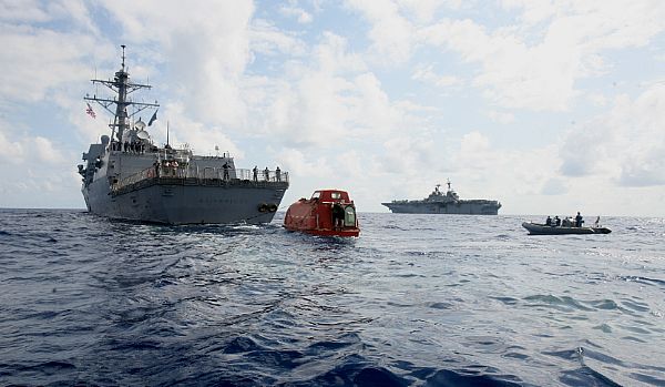NDIAN OCEAN (April 13, 2009) The guided-missile destroyer USS Bainbridge (DDG 96) tows the lifeboat from the Maersk Alabama to the amphibious assault ship USS Boxer (LHD 4), in background, to be processed for evidence after the successful rescue of Capt. Robert Phillips. Phillips was held captive by suspected Somali pirates in the lifeboat in the Indian Ocean for five days after a failed hijacking attempt off the Somali coast. Boxer is deployed as part of Boxer Amphibious Readiness Group/13th MEU supporting maritime security operations in the U.S. 5th fleet area of responsibility. Maritime security operations help develop security in the maritime environment and compliment the counterterrorism and security efforts of regional nations. From security arises stability that results in global economic prosperity. These operations seek to disrupt violent extremistsÕ use of the maritime environment to transport personnel and weapons or serve as a venue for attack. (U.S. Marine Corps photo by Lance Cpl. Megan E. Sindelar/Released)