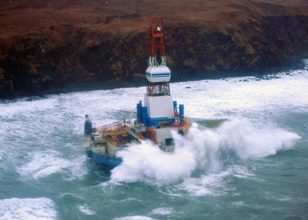 Waves crash over the conical drilling unit Kulluk where it sat aground on the southeast side of Sitkalidak Island, Alaska, Jan. 1, 2013. U.S. Coast Guard photo by Petty Officer 3rd Class Jonathan Klingenberg.